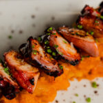 Plato de carne sobre puré naranja